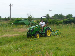Student worker mowing selected plots.
