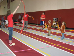 Education students leading activities for young children during mini-olympics